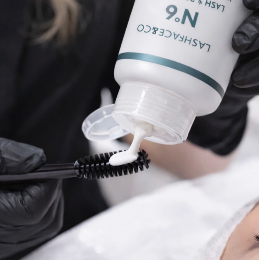Doseringen av Lash & Brow Mask Nº6 på en svart spoolie, med flaskan bredvid.